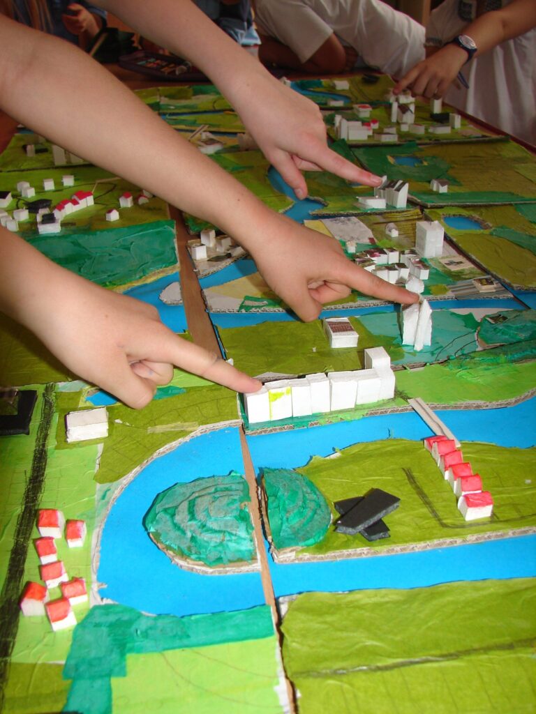 fragment makiety miasta złożonej z dzielnic- dzieci wskazują na zaprojektowane budynki
