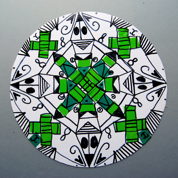 Mandala narysowana przez dziecko- czarne linie oraz zielona folia transparentna. w niektórych miejscach folia klejona dwoma warstwami co daje efekt ciemniejszego koloru.